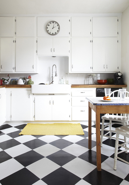 White older kitchen with butchers block counters and checker board floor