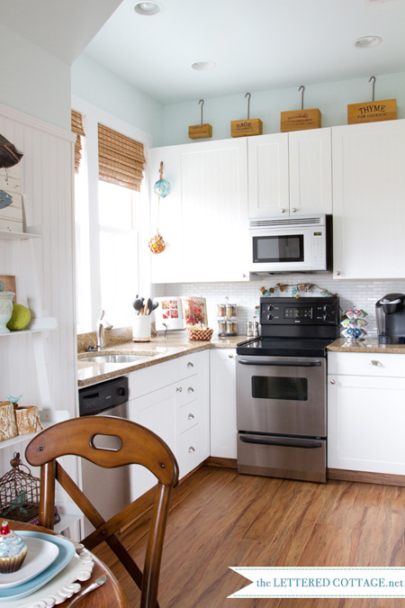 White kitchen with gold granite countertops from the Lettered Cottage