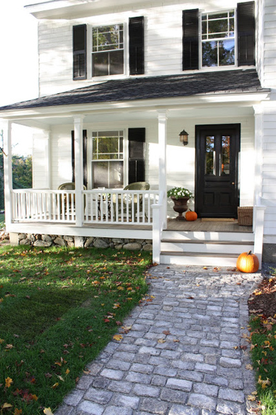 White house with black shutters and black front door and white porch