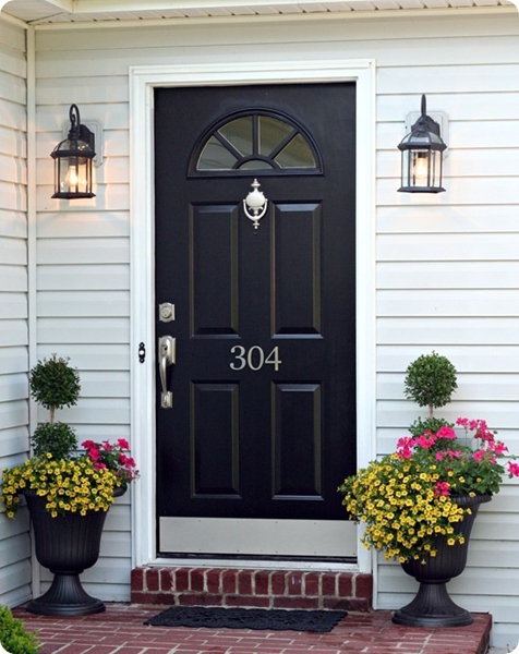 Black front door with black urns and lights