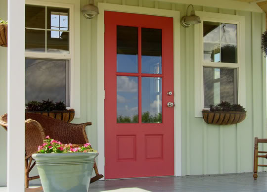 Coral pink front door with green board and batten
